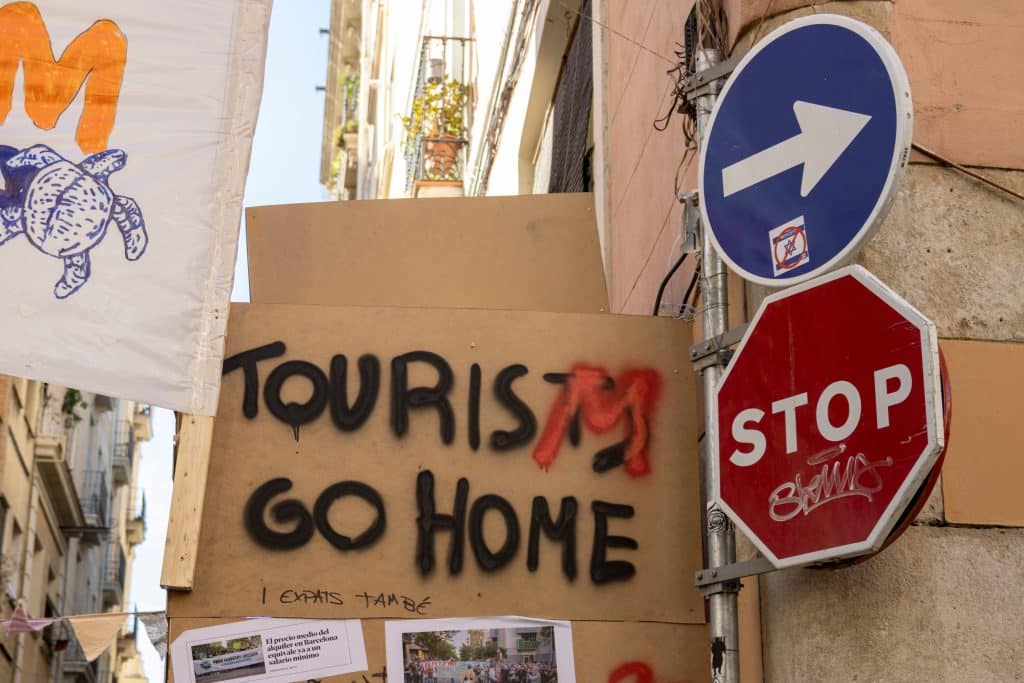 Signs protesting overtourism say "Tourism Go Home"