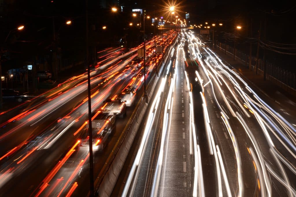 Blurred car lights illuminate the street of a big city highway.