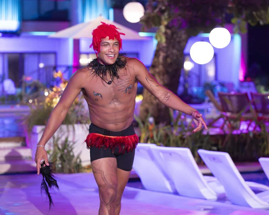 Dale walks in with a red feathered wig.