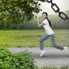A woman escaping from a grey, chain-filled area. Running towards the bright green grass with a big smile on her face.