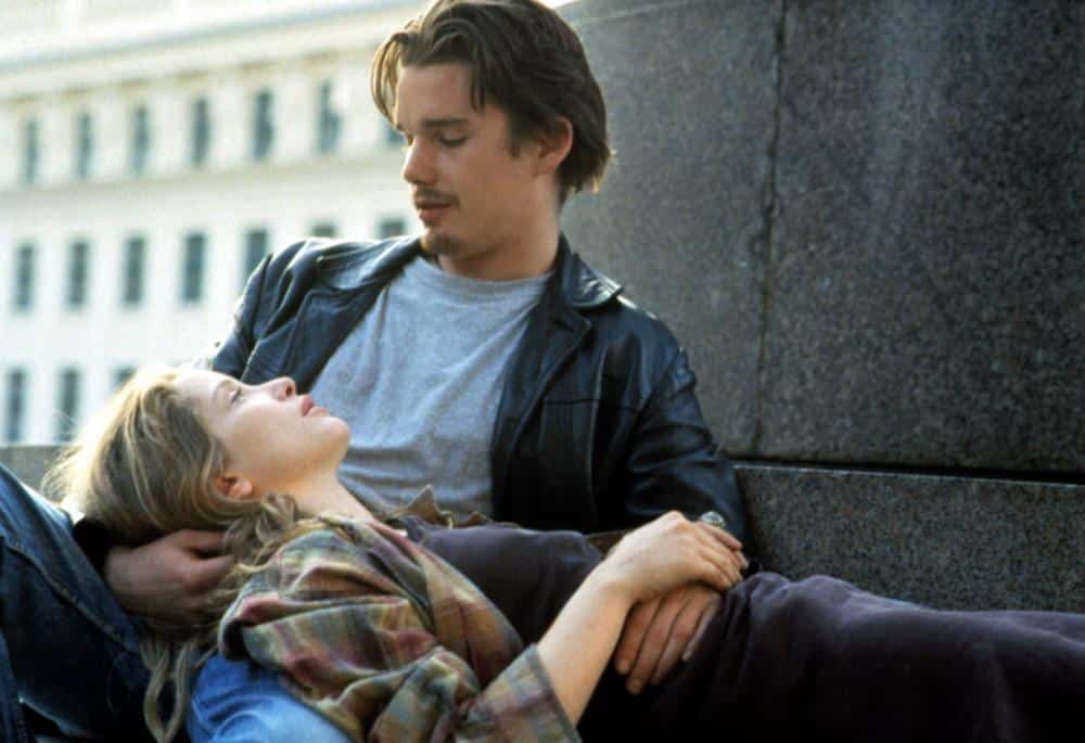 Celine lays across Jesse's lap as they sit on a bench.