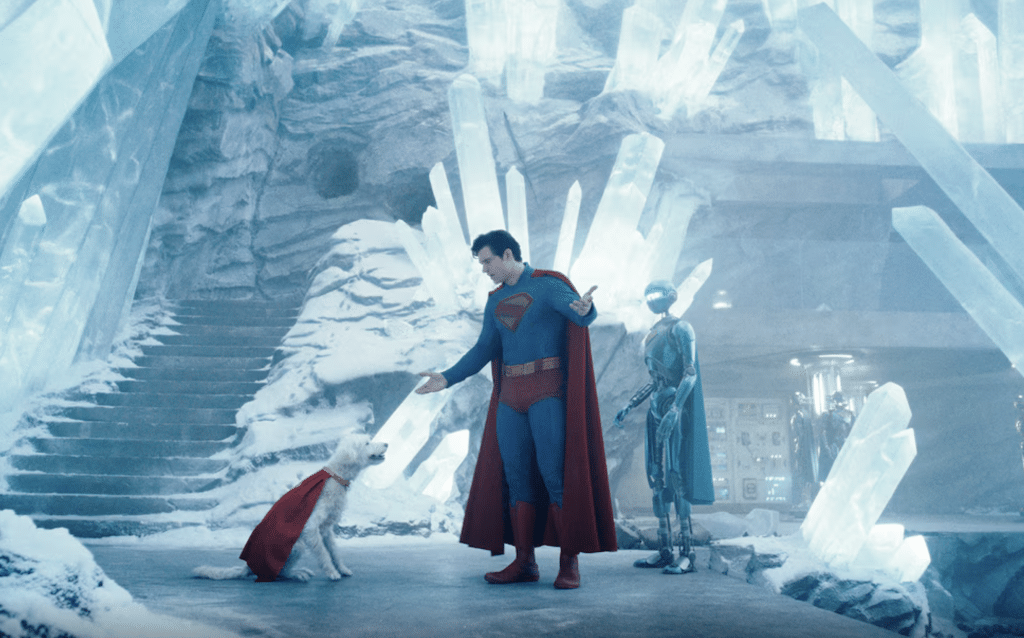 Still from 'Superman' (2025) showcasing the titular hero arguing with his dog, Krypto, alongside one of his robots at the 'Fortress of Solitude'.