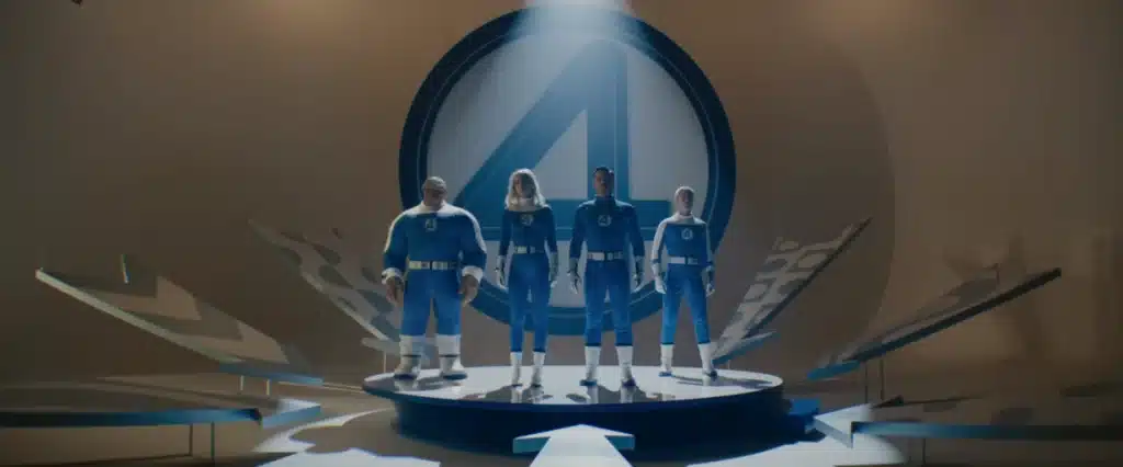 Fantastic Four stand triumphantly on a podium in their costumes.