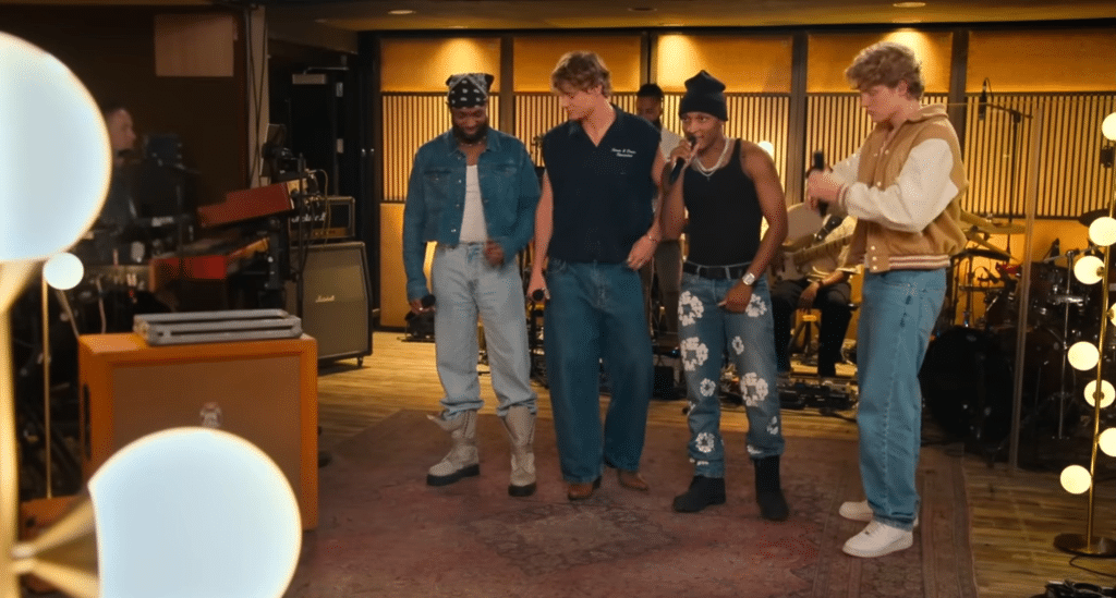 4 boys singing together in a studio.