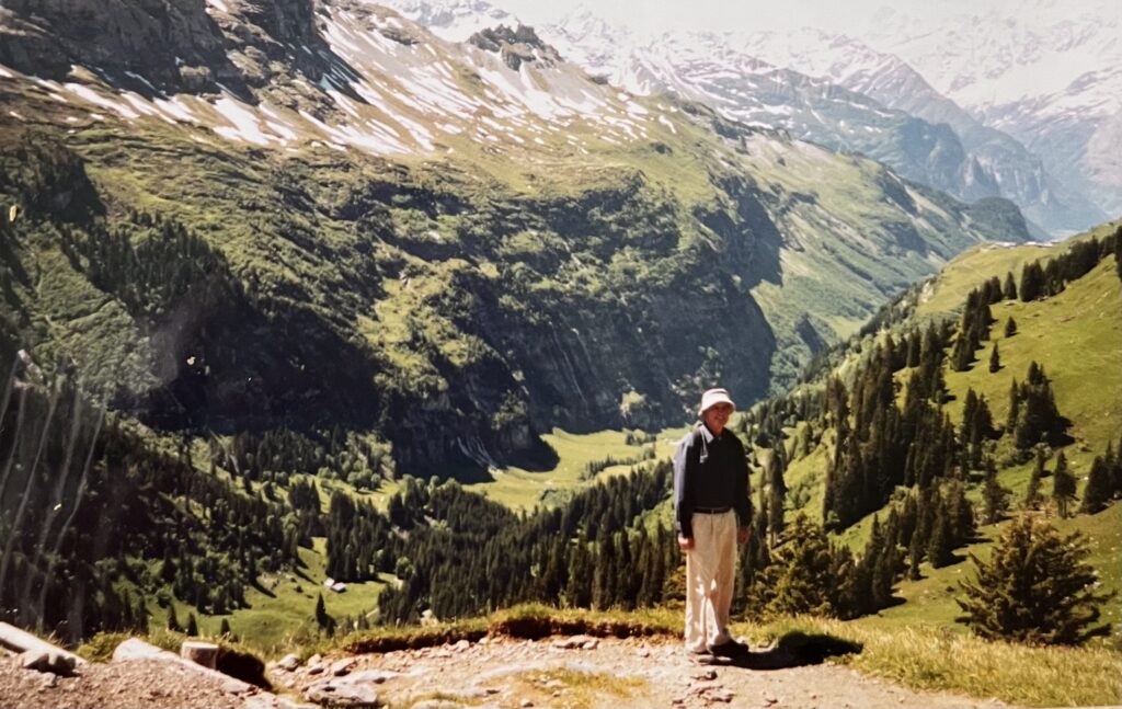 Woman standing on a hiking trail with a big mountain behind her