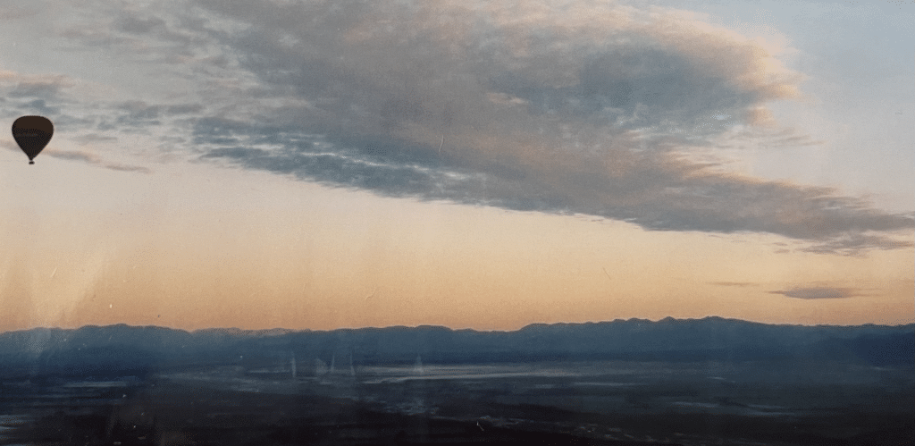 Picture of a hot air balloon in the sky during sunrise.