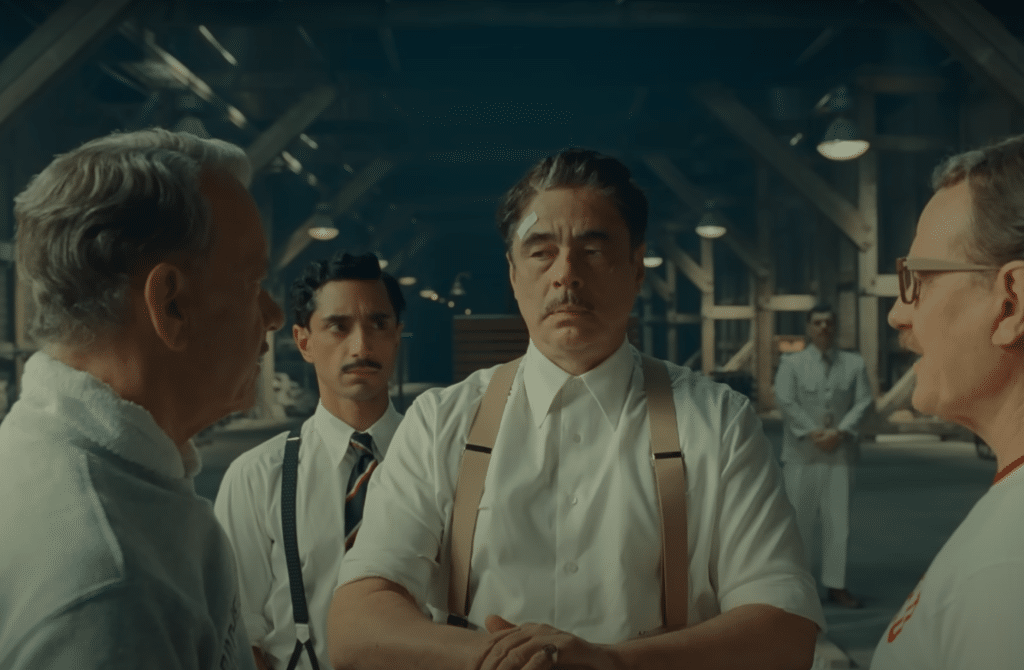 Benicio del Toro as Zorda discussing plans in The Phoenician Scheme 2025