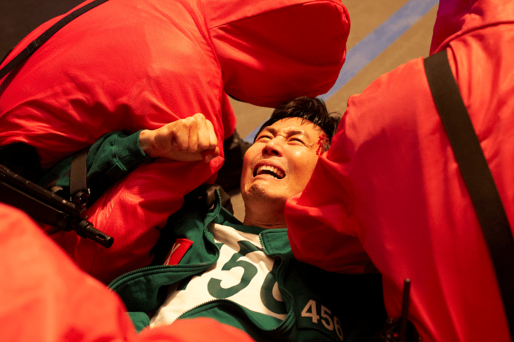 Gi-hun in Squid Games getting dragged away by the pink guards.