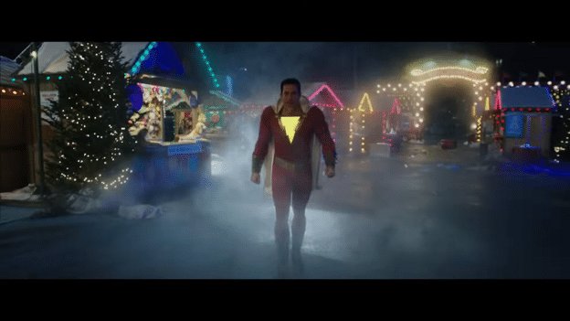 Shazam (Zachary Levi) walking through a Christmas celebration