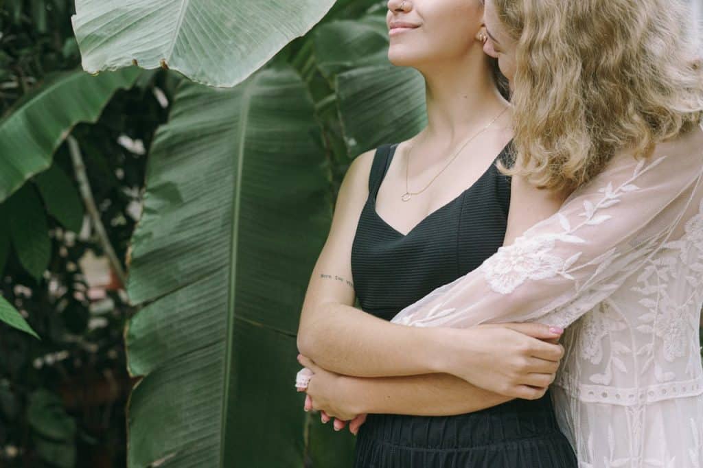Two women embrace each other.