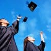 Two graduates throwing their caps in the air.