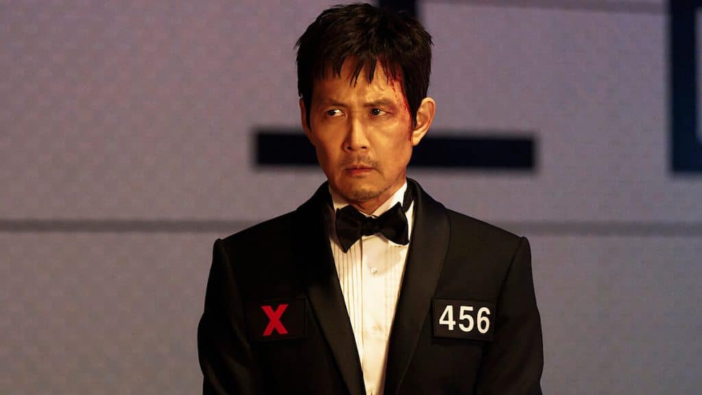 Gi-hun from Squid Games wearing a suit.