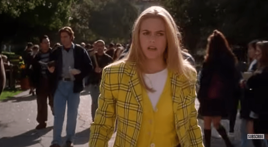 A girl walking down the street looking disgusted.