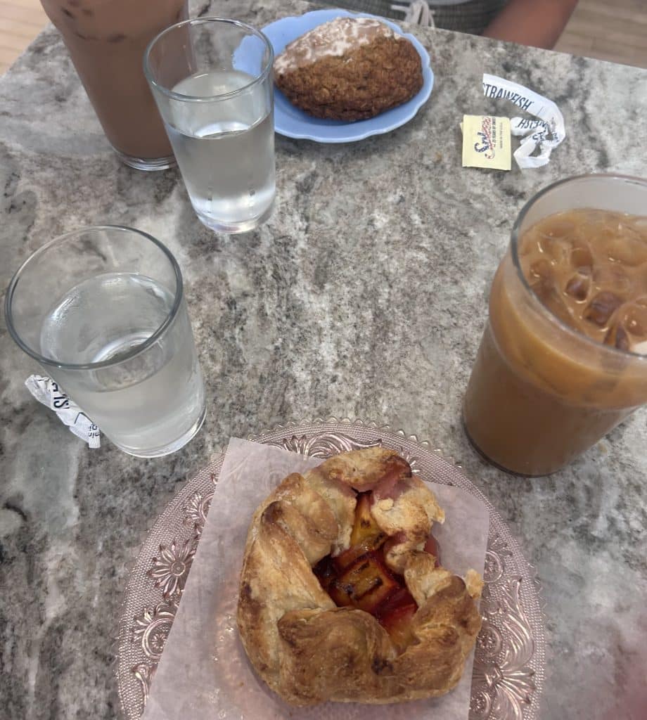 A caramel iced coffee and cherry-peach galette pastry accompanied by a mocha coffee and oatmeal cookie at Bev's Café.