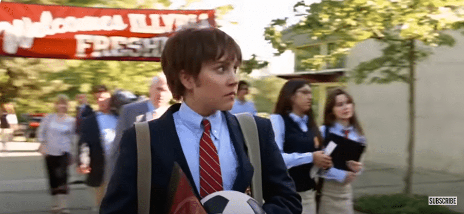 A school student carrying a football.