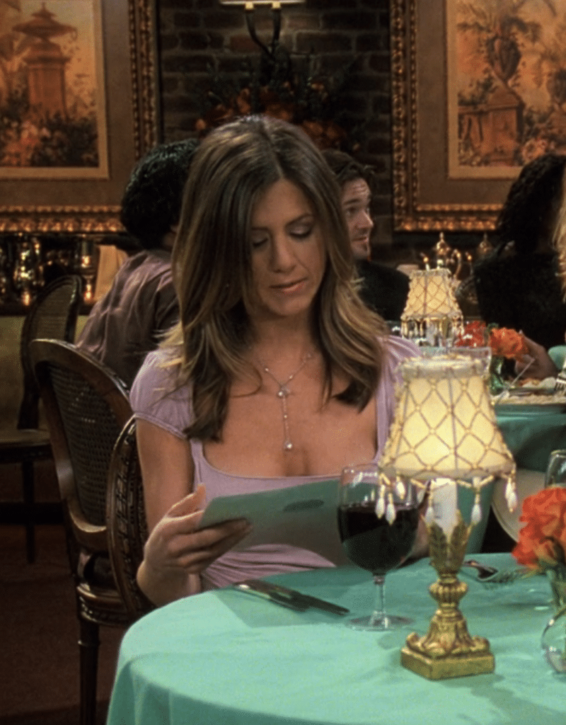 Jennifer Aniston as Rachel Green in 'Friends' wearing an off-pink blouse with a pearl necklace. (Credit: Warner Bros. Television via HBO Max/Hulu)