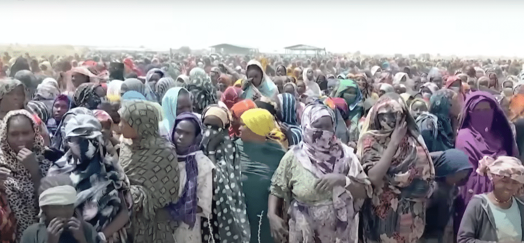 Hundreds of Sudanese refugees waiting to receive food and medicine. Credit: DW Documentary (YouTube)