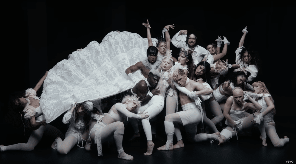 A still shot from Lady Gaga's "Abracadabra" music video, depicting Gaga and backup dancers in all white.