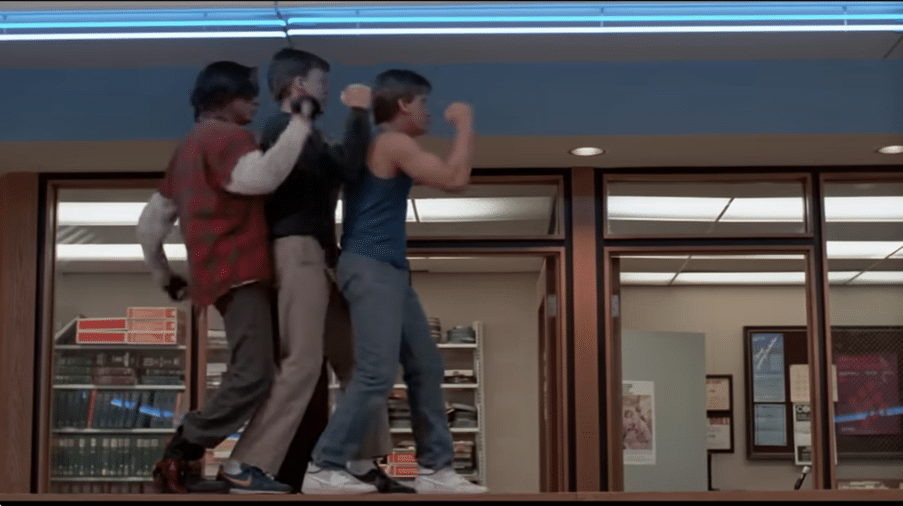 Three teenage boys walking on a table with their arms at a 90 degree angle.