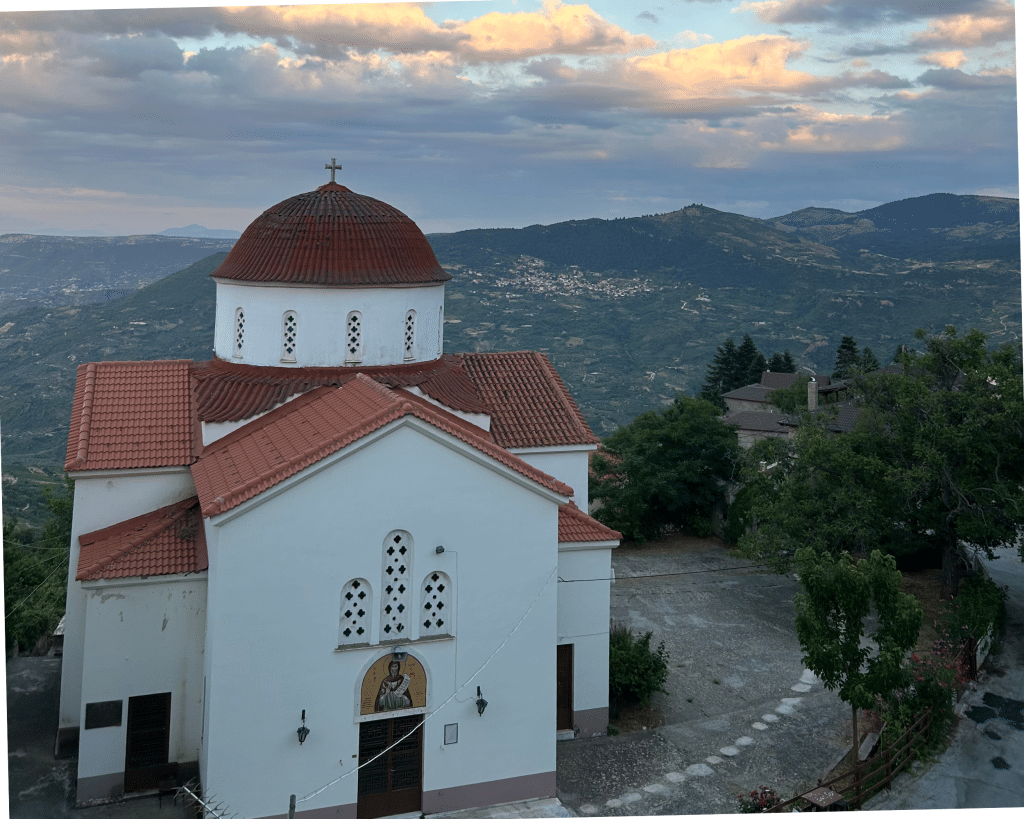 Church sitting on top of a hill with views of lush, green land