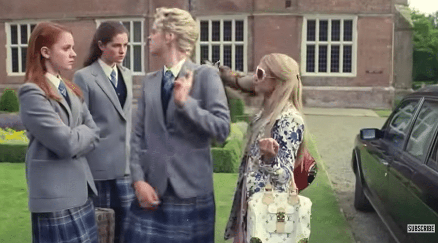Three girls in school uniforms confront a fourth girl whose holding luggage.