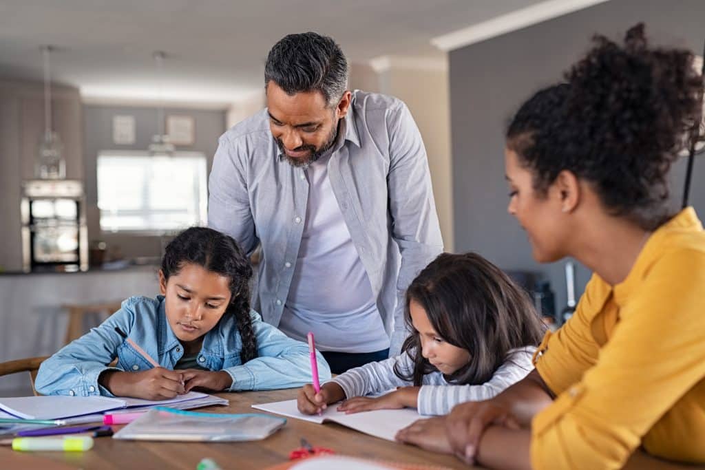 Parents teaching their two children to do their homework