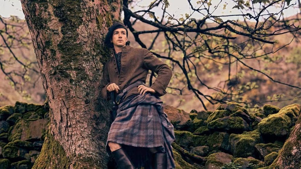 Rory Alexander as Lord Lovat leaning against tree in 'Outlander: Blood of my Blood"