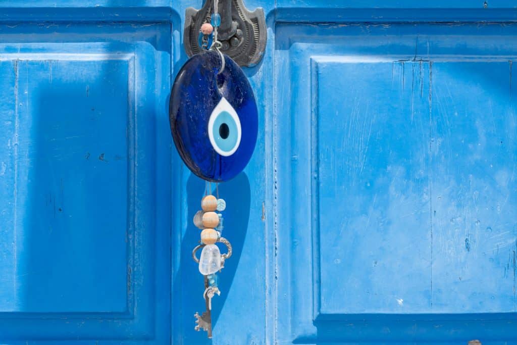 Dangling evil eye over a blue background