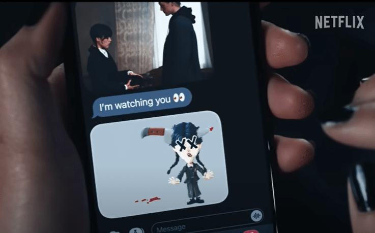 A girl looking at texts on her phone. The texts include a photo of Wednesday and Xavier, a cartoon image of Wednesday with a knife in her head, and the message, "I'm watching you."