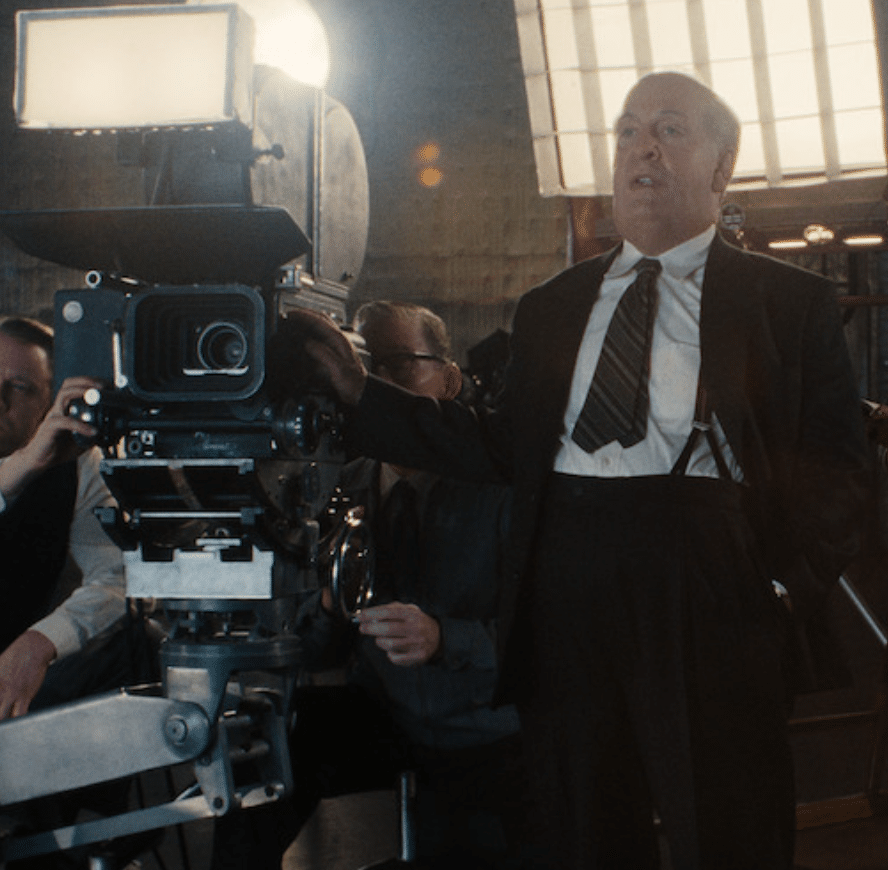 Tom Hollander as Alfred Hitchcock directing on a set in Monster: The Ed Gein Story.