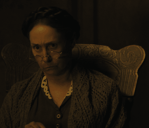 Laurie Metcalf as Augusta Gein sitting in a chair in Monster: The Ed Gein Story.