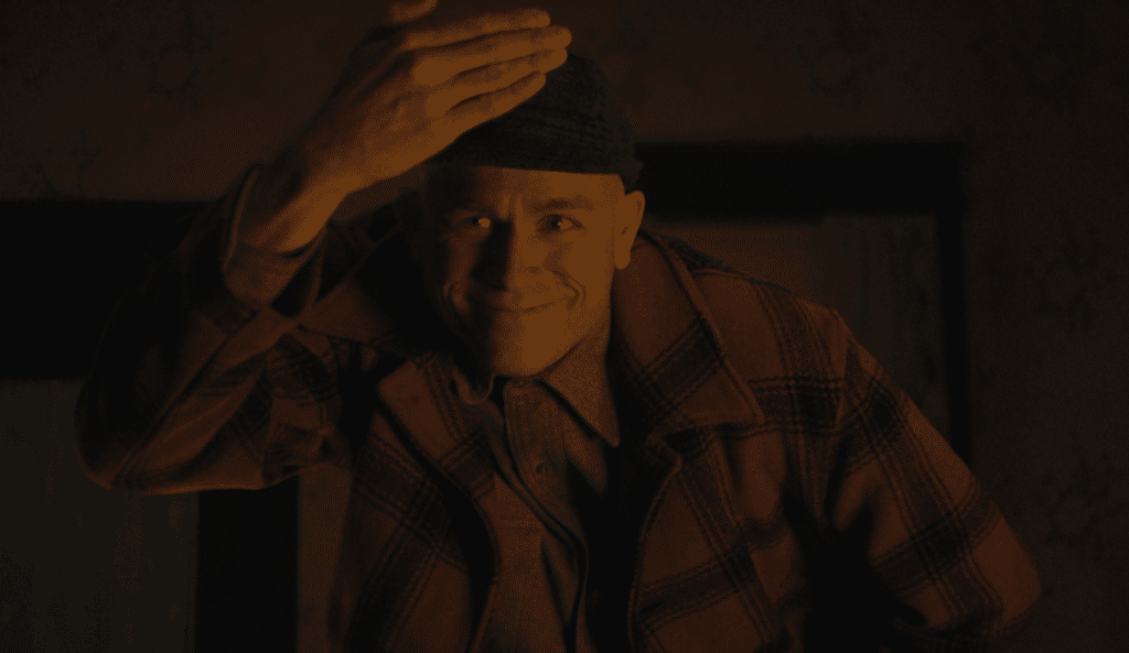 Charlie Hunnam as Ed Gein smiling at the camera in Monster: The Ed Gein Story.