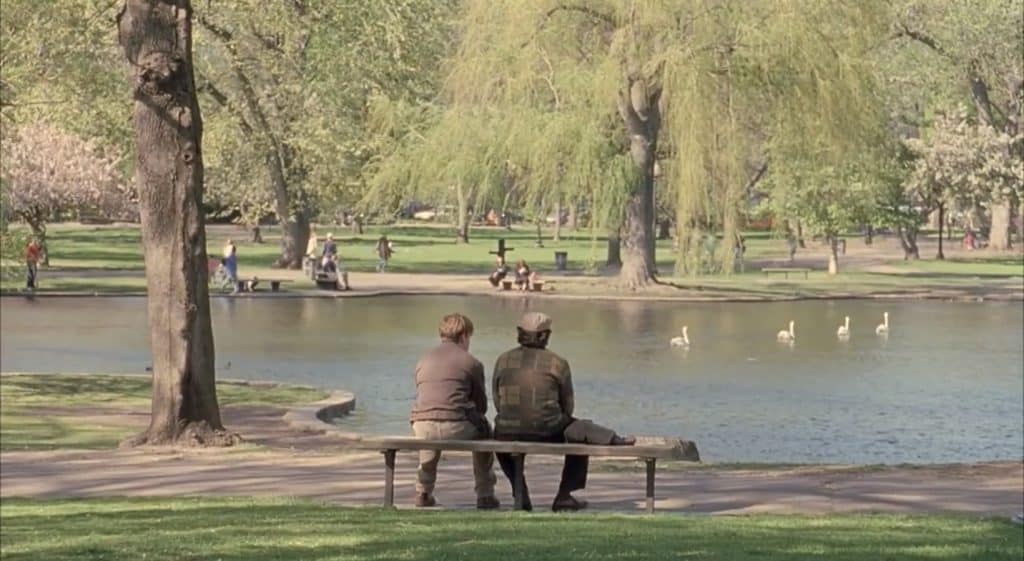 Two men sit on a bench in the park