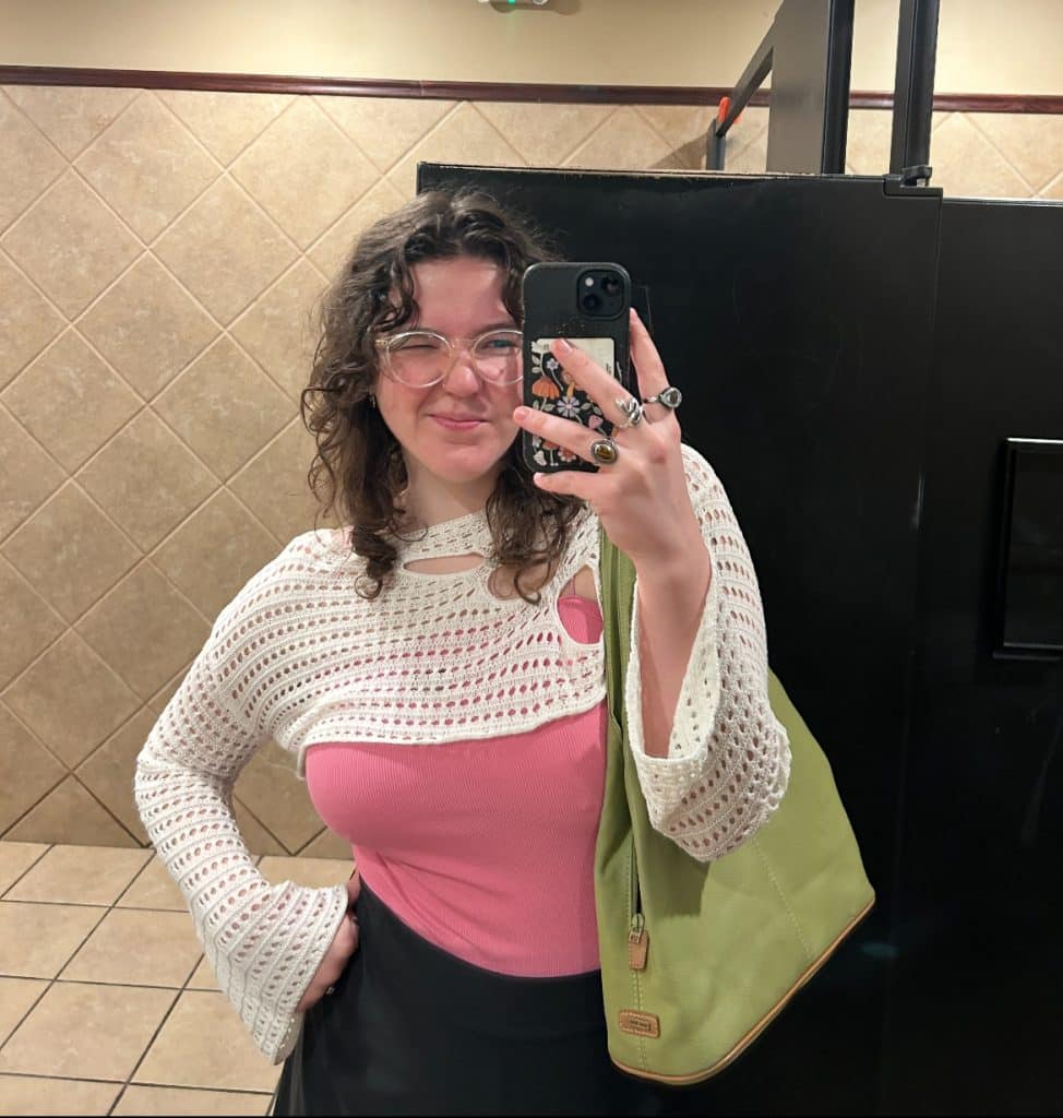 Young woman holding green purse