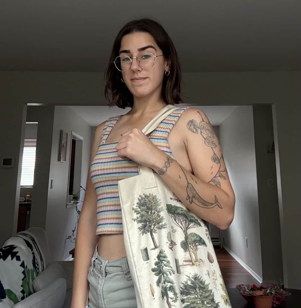 Young woman holding a tote bag with tree decals