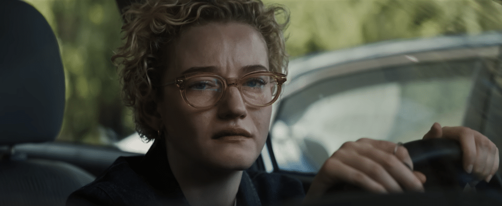 Woman upset in her car in the movie, Weapons.