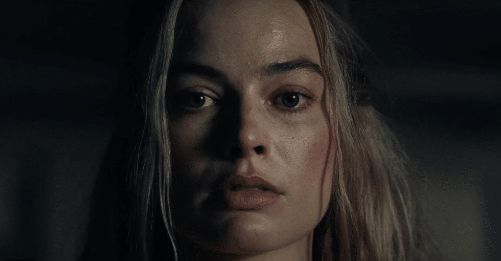 Margot Robbie stares directly into camera.