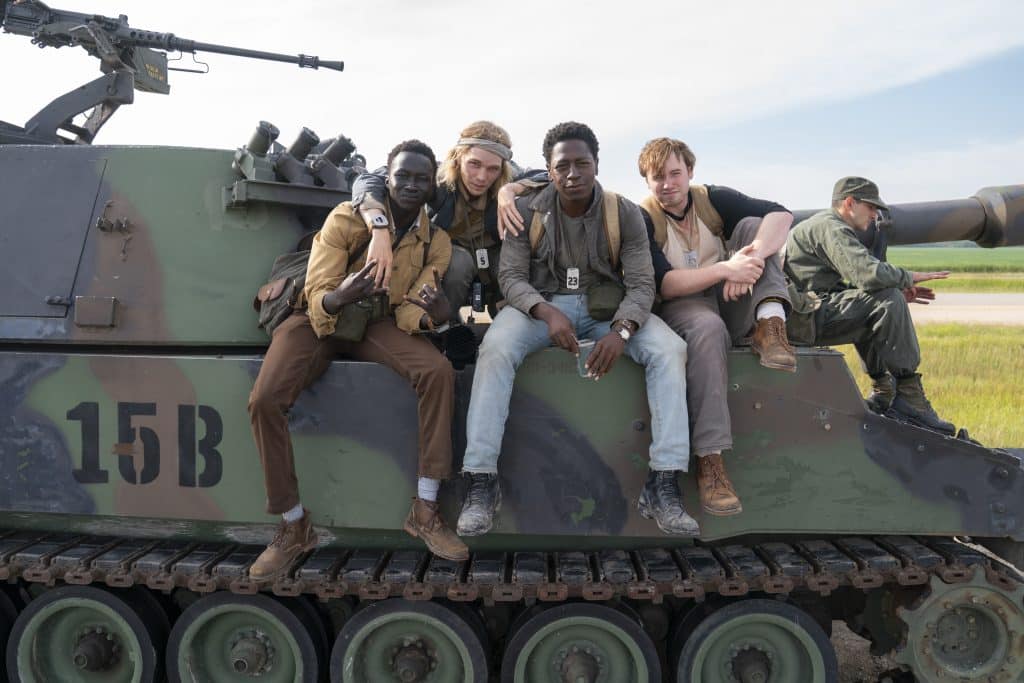 L-R: Tut Nyout, Charlie Plummer, David Jonsson, and Cooper Hoffman sitting on a tank