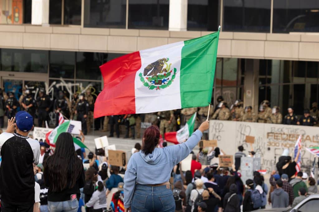 People hold Mexican flags in protest of the Trump Administration’s ICE deportation raids in Downtown LA.