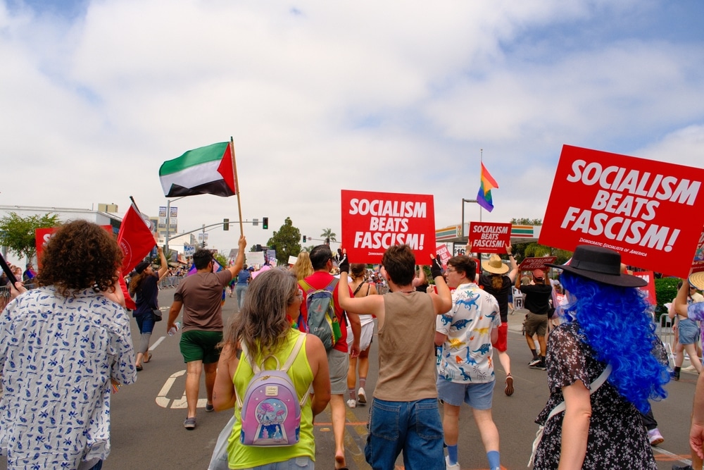 Members of the Democratic Socialists of America (DSA) march with "Socialism Beats Fascism" signs.