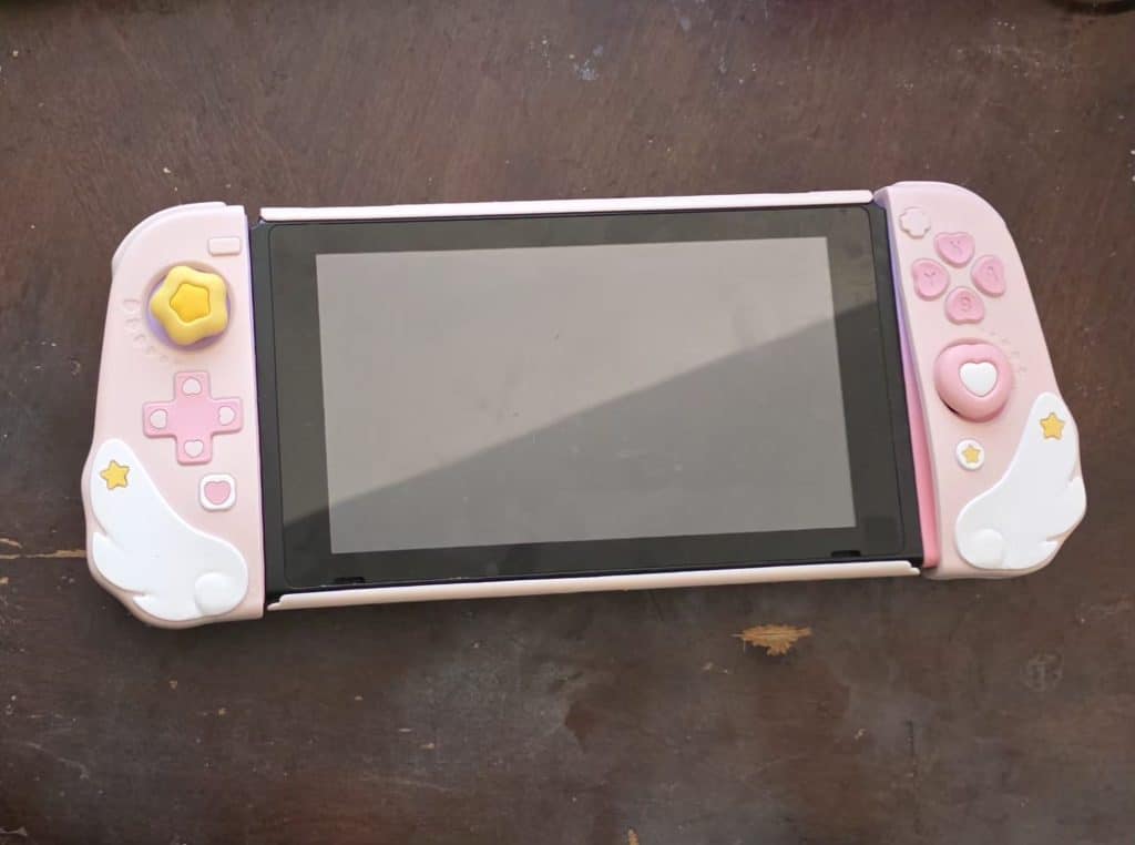 My original Nintendo Switch with a pink and white and gold case.
