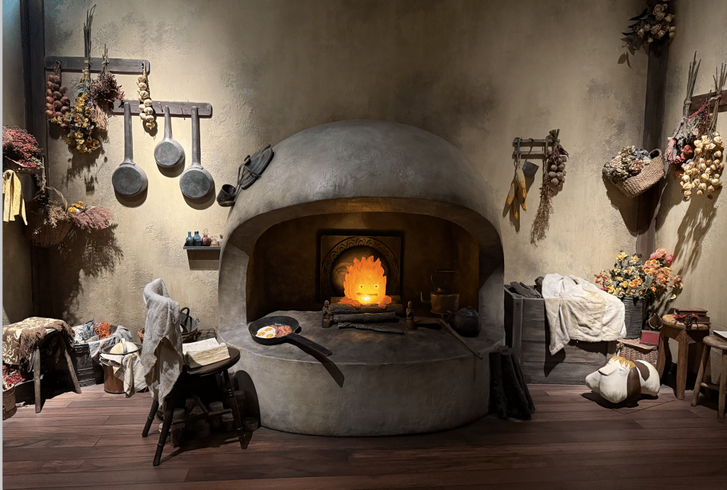 Sculpture of Howl's kitchen, with Calcifer peeking out from the oven.