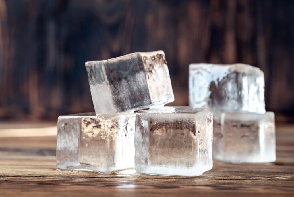 On the room's table sits an ice cube currently absorbing heat, which has not yet melted.