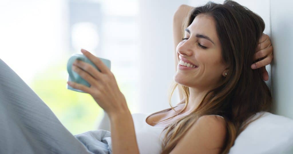 a women smiling lying on the sofa