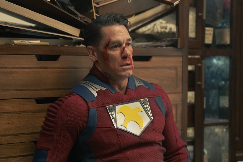 Chris Smith (John Cena) sitting against a shelf, looking bloodied and defeated.