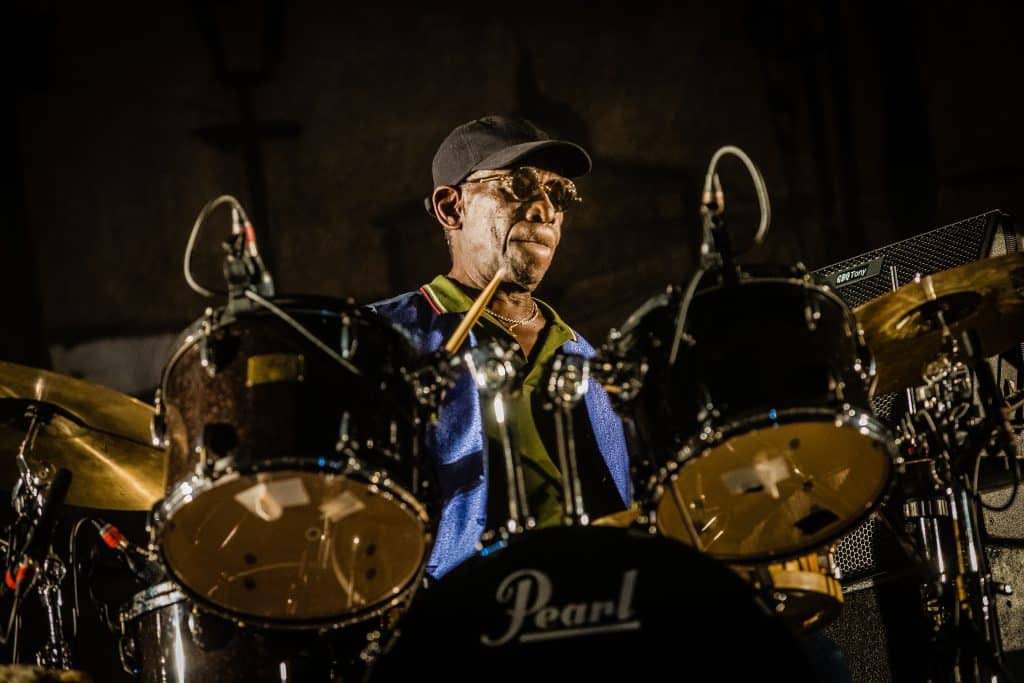 A close up of a man on a drum set.