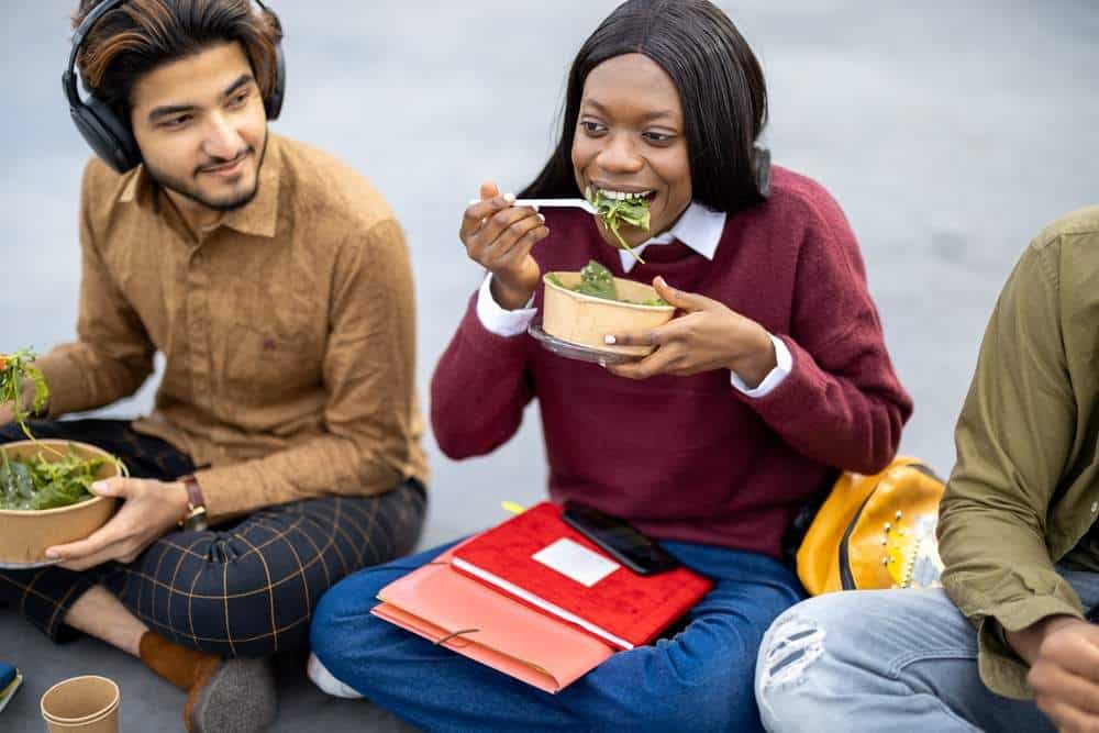 College students sat outside eating their healthy lunch.
