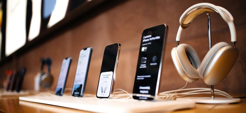 A row of Apple products, three varieties of iPhones and some wireless headphones