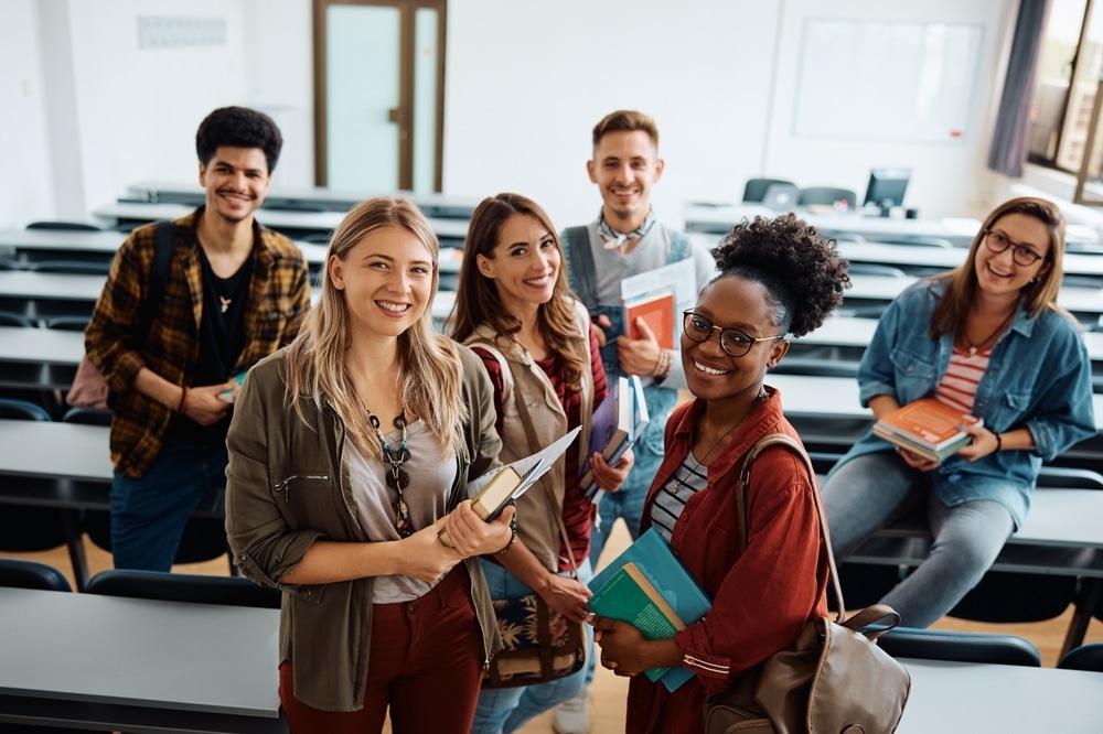 Six students standing together in a classroom.