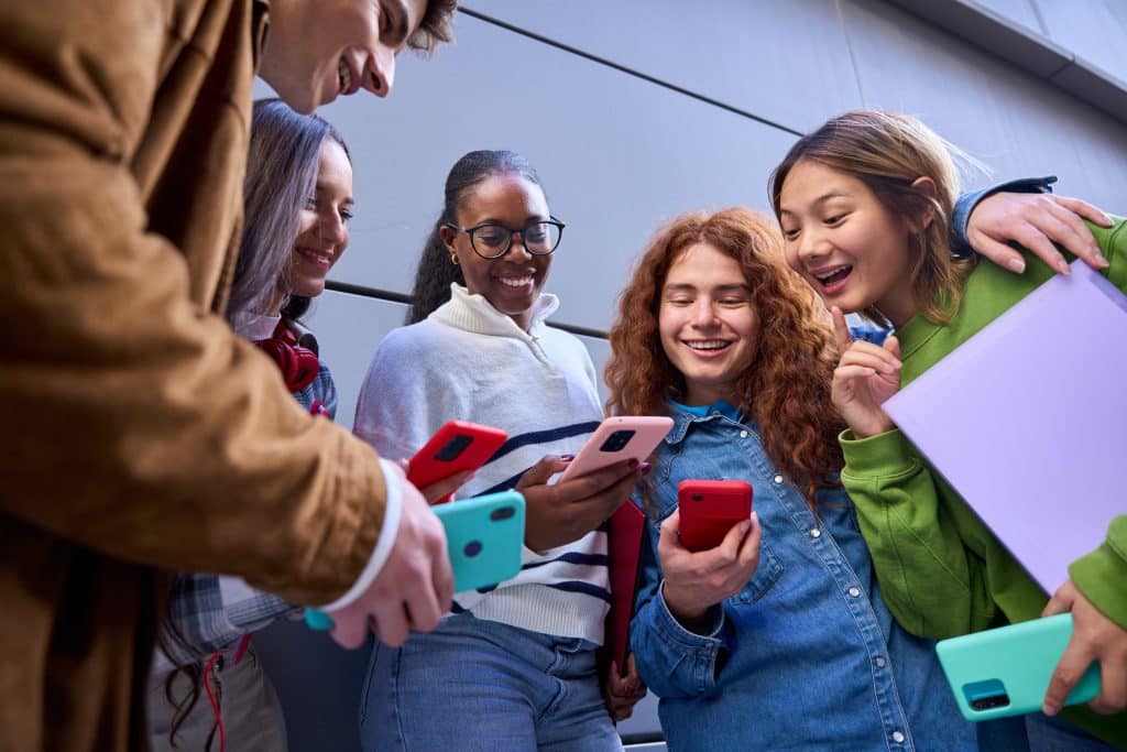 A group of young people looking at their phones.